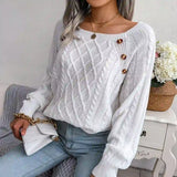 White cable-knit sweater styled with light-wash jeans, chic casual look